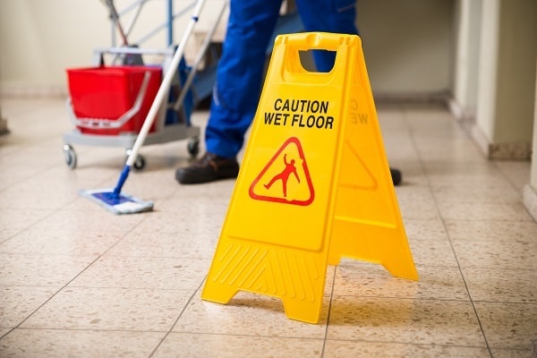 janitor mopping floor to avoid slips and falls