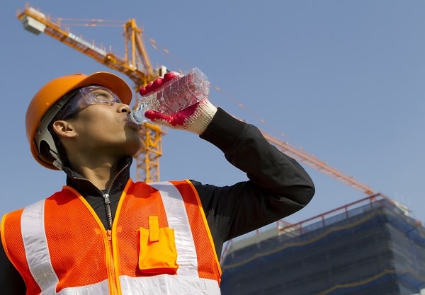 construction worker protecting himself from heat stress by staying hydrated